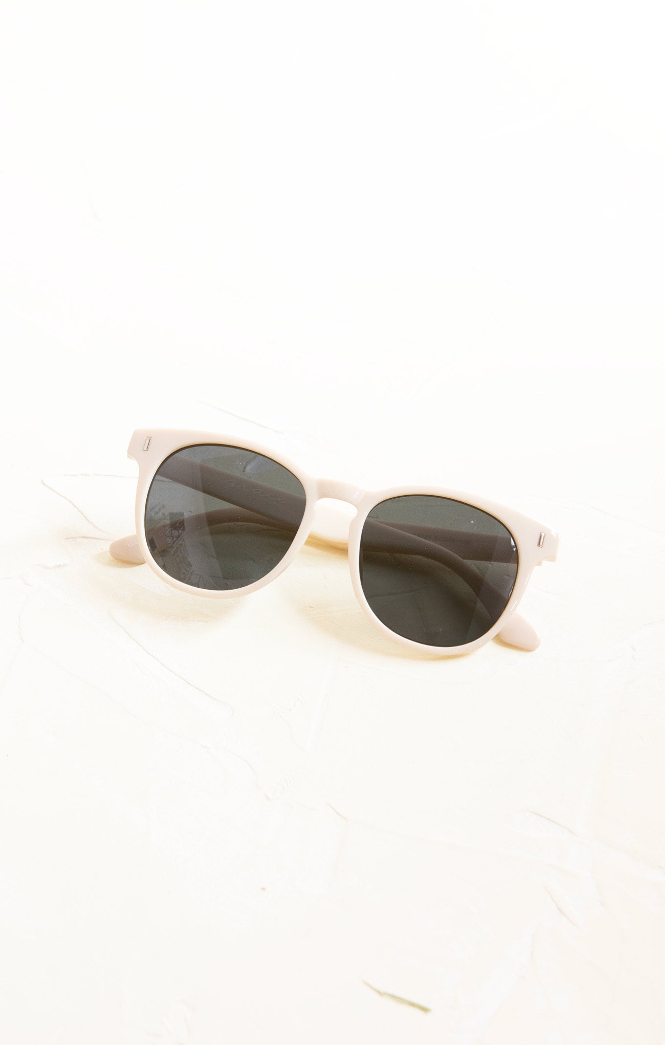 Sunglasses with gold frame and dark lenses on a white background