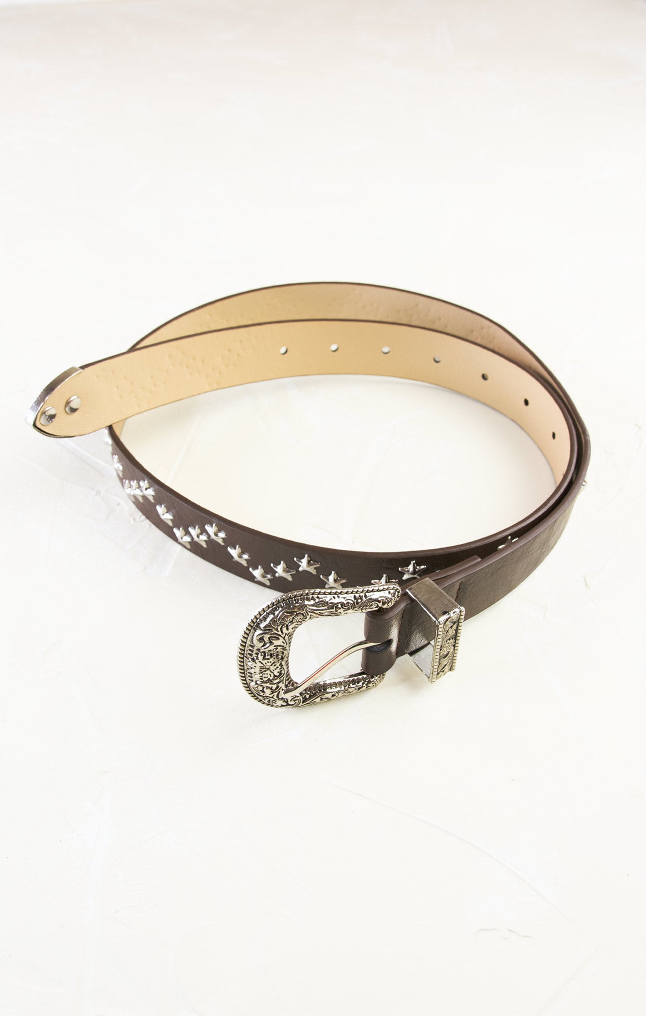 Brown leather belt with decorative buckle on a white background