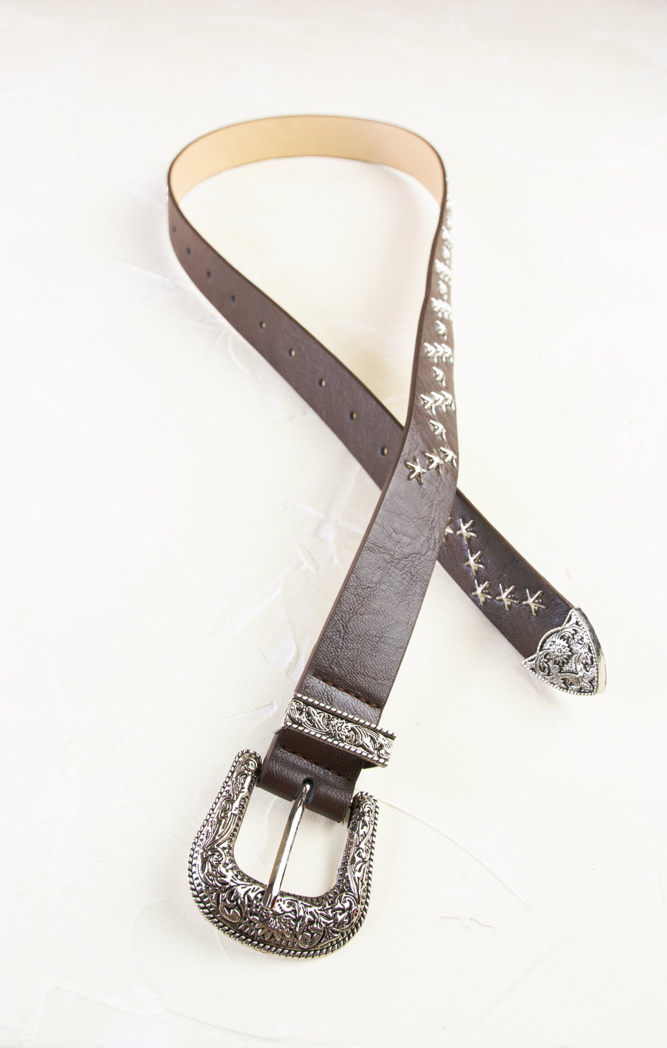 Brown leather belt with decorative buckle on a white background