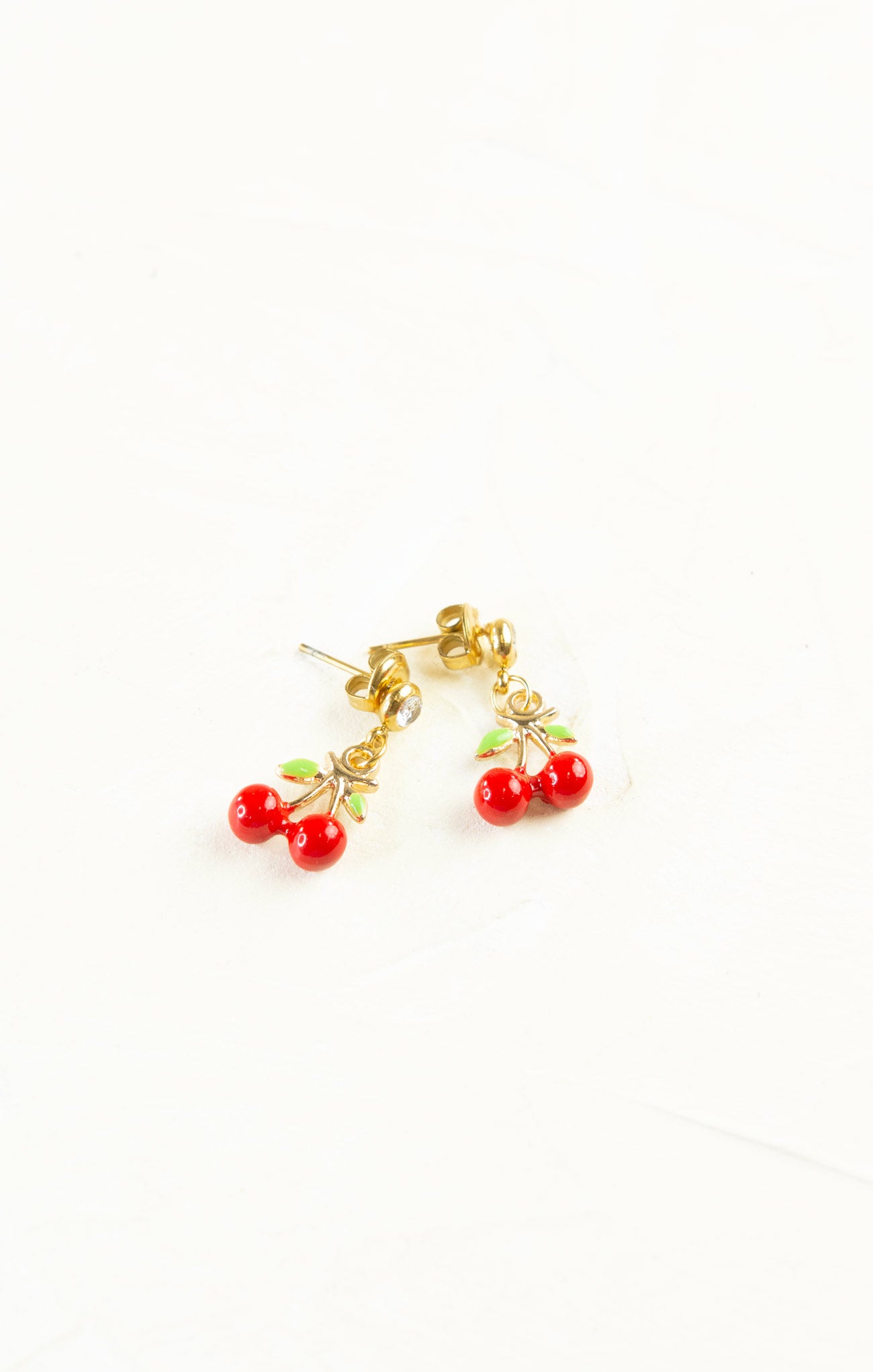 Cherry-themed earrings on a white background