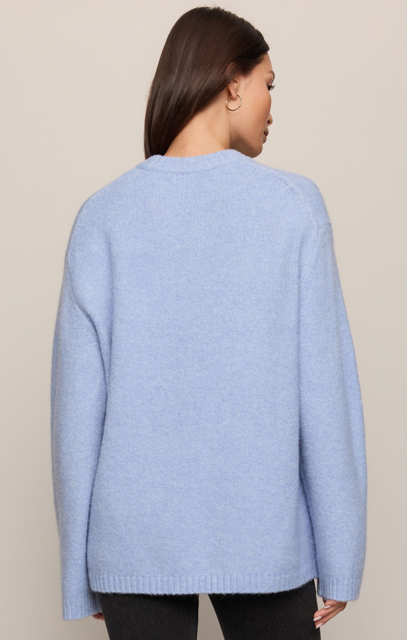 Light blue sweater worn by a person on a beige background