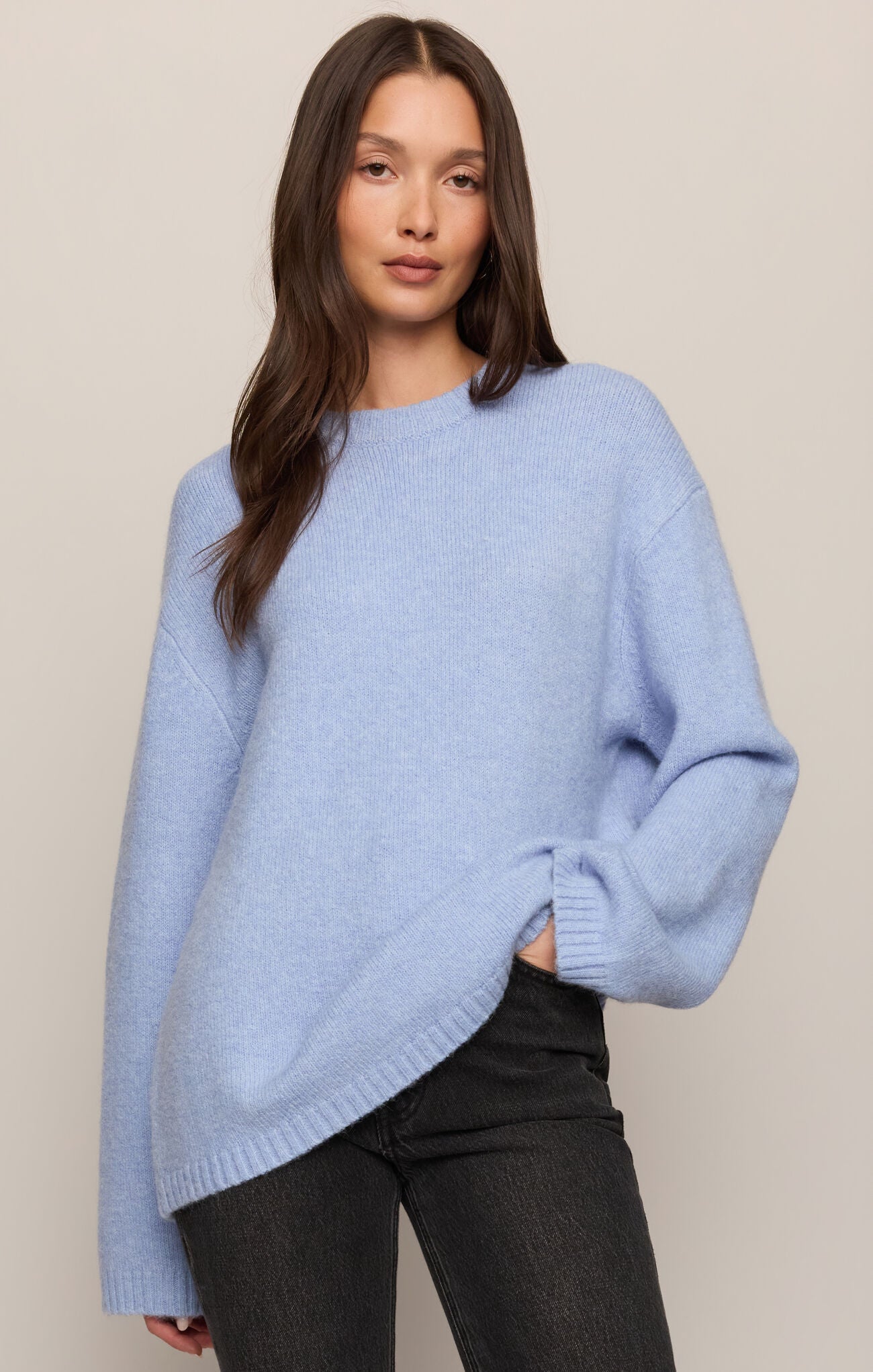 Woman wearing a light blue sweater against a plain background