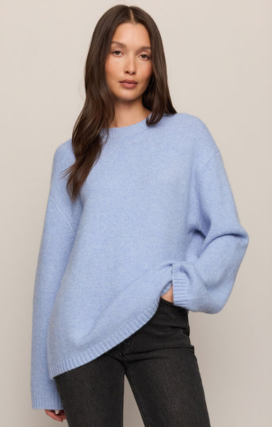 Woman wearing a light blue sweater against a plain background