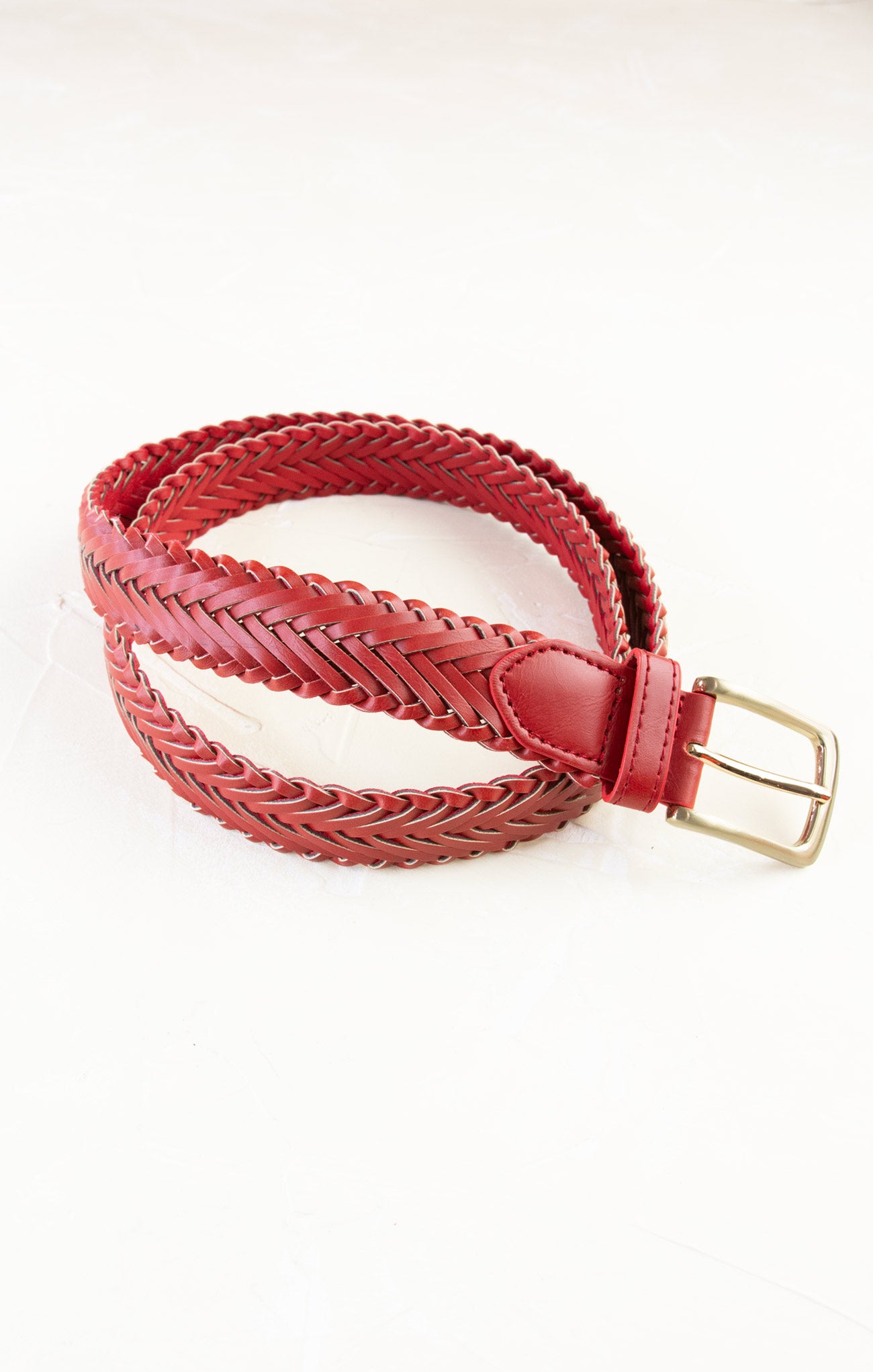 Red braided belt with a gold buckle on a white background