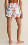 Person wearing colorful floral shorts on a neutral background