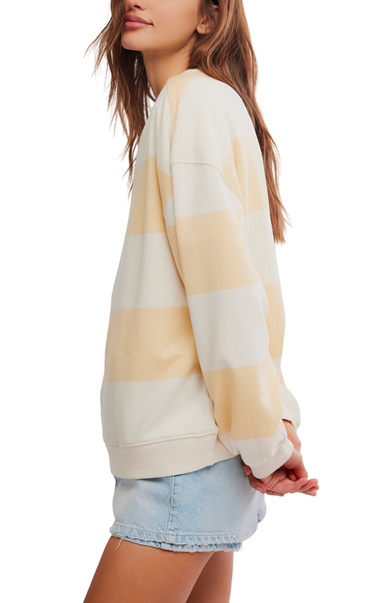 Woman wearing a striped sweater and denim shorts on a white background