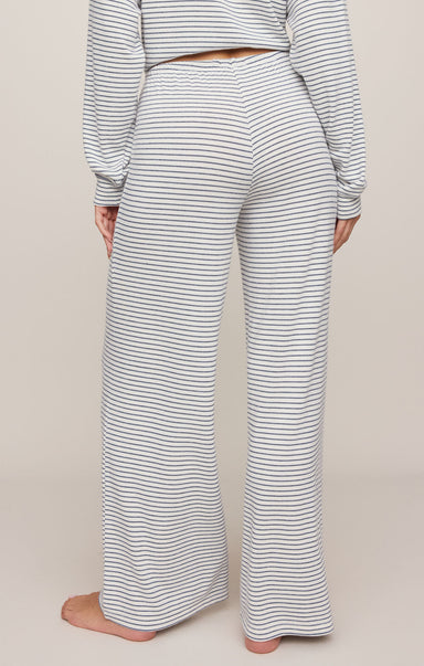 Person wearing a striped outfit with wide-leg pants on a plain background