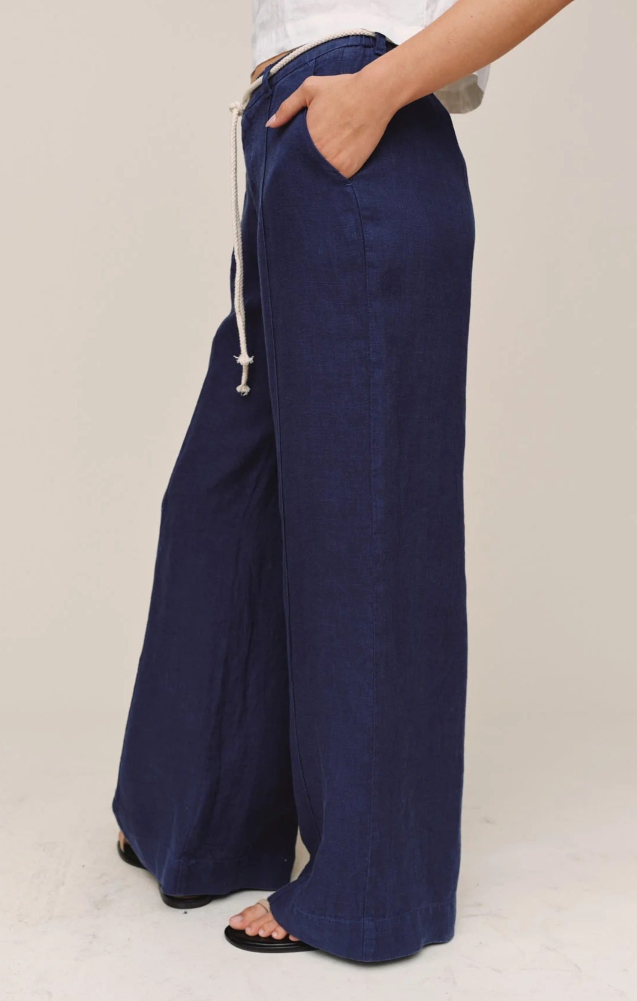 Navy wide-leg pants worn by a person on a plain background