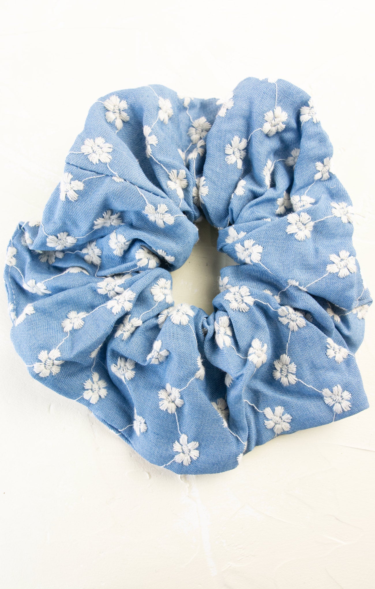 Blue floral scrunchie on a white background