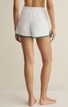 White shorts with green trim worn by a person on a neutral background