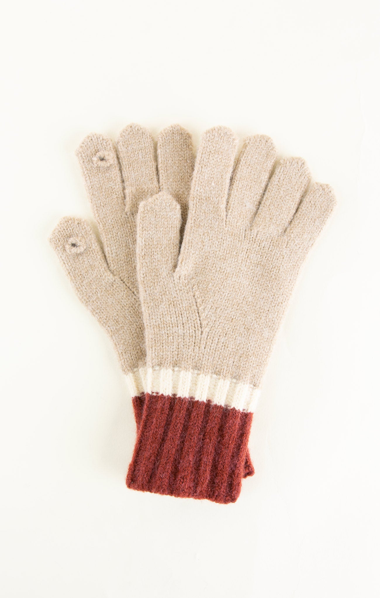 Pair of gloves with beige body and red cuffs on a white background