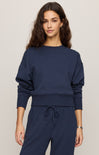 Woman wearing a navy blue outfit on a plain background