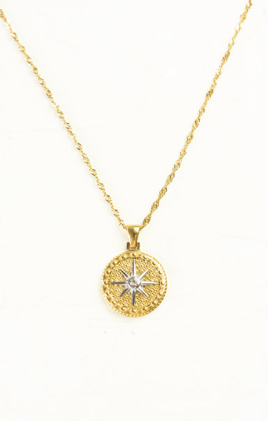 Gold necklace with a star pendant on a white background