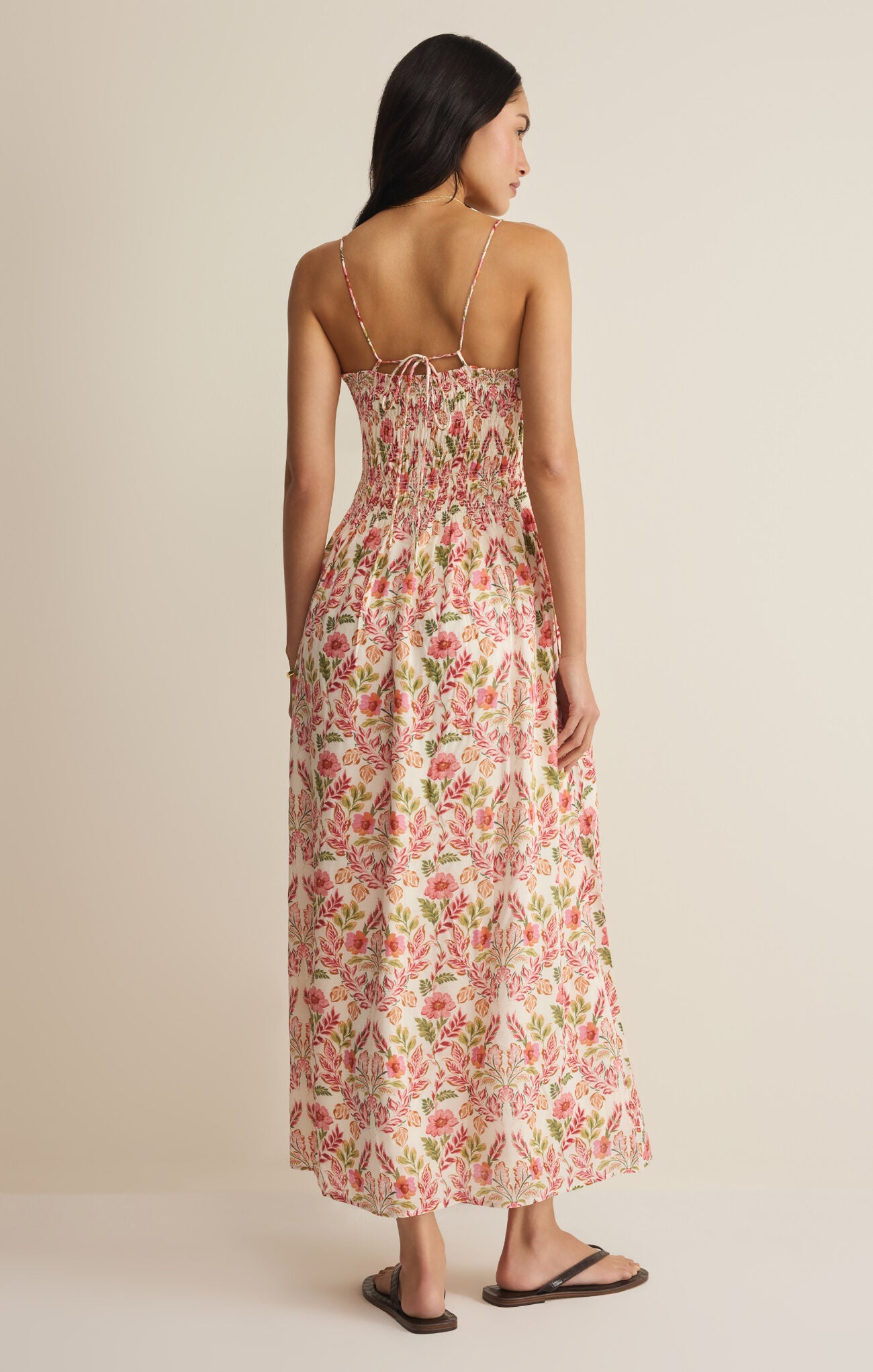 Woman wearing a floral dress against a beige background