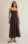 Woman wearing a brown dress against a beige background