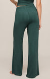 Green ribbed pants worn by a person on a beige background