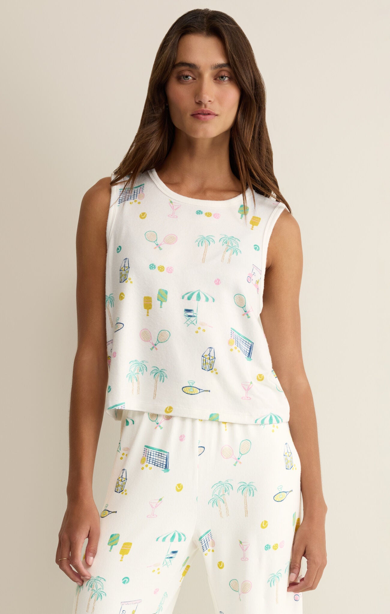 Woman wearing a white sleeveless top with colorful pattern on a beige background