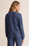 Woman wearing a blue sweater and pants on a beige background