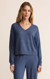 Woman wearing a blue sweater and pants on a beige background