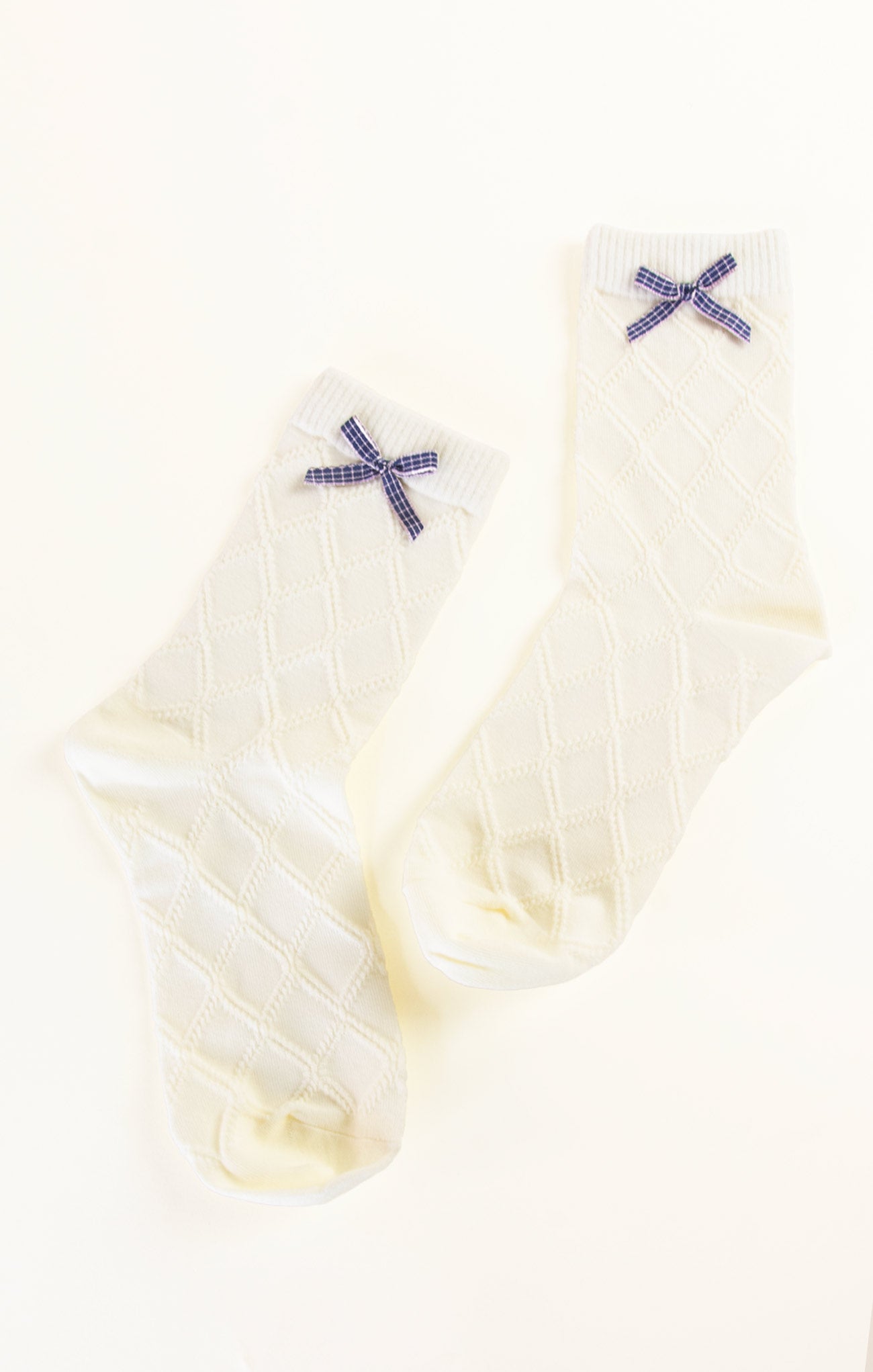 Pair of white socks with blue X designs on a white background