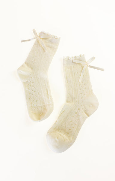 Pair of cream-colored socks with bow details on a white background