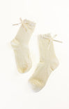 Pair of cream-colored socks with bow details on a white background