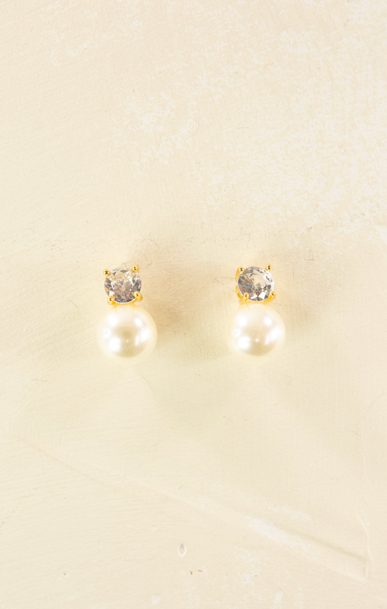 Pair of earrings with gemstones on a beige background