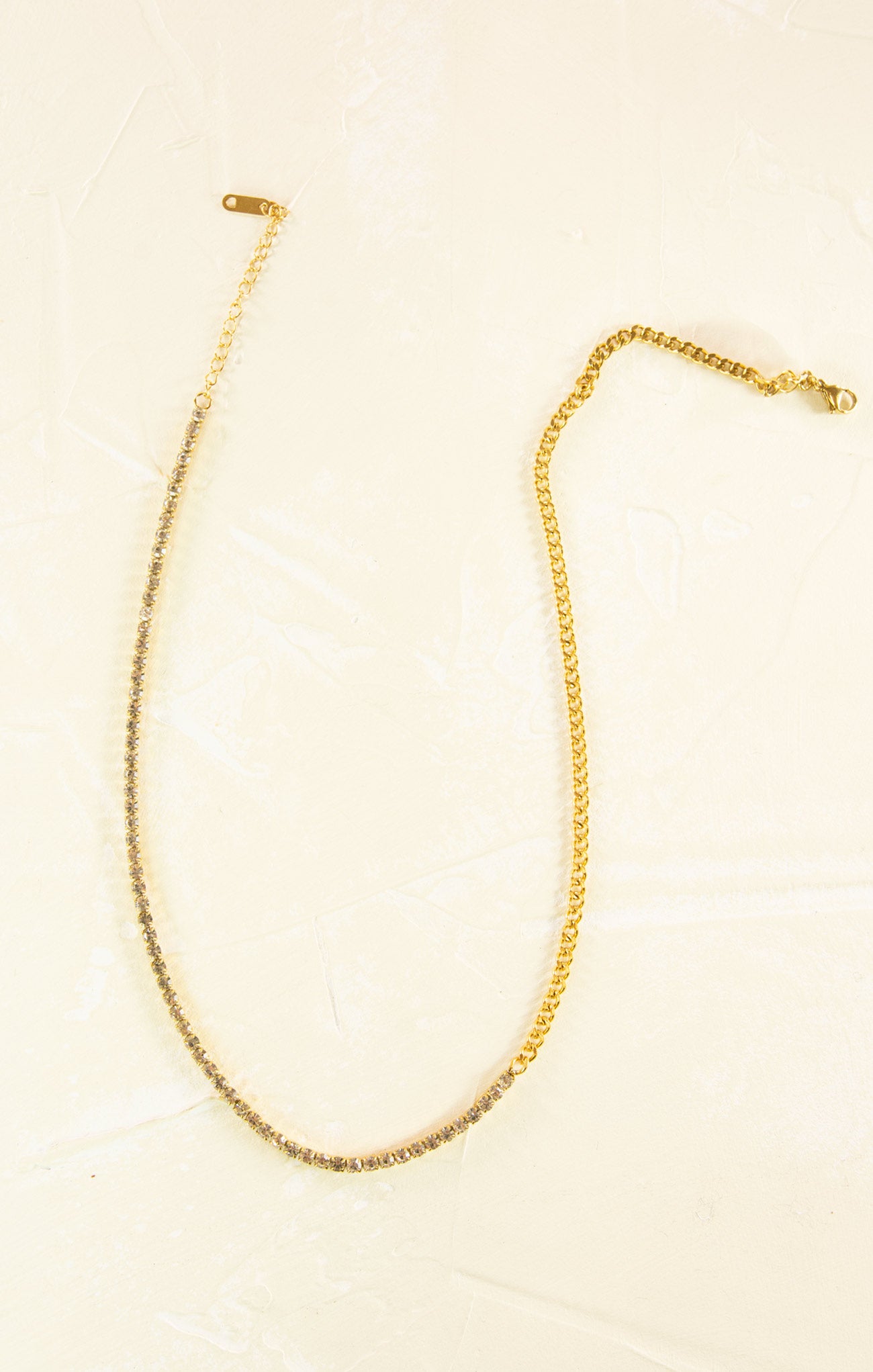 Gold necklace on a beige background