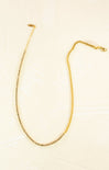 Gold necklace on a beige background