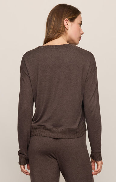 Woman wearing a brown sweater and pants set on a beige background