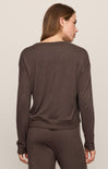 Woman wearing a brown sweater and pants set on a beige background