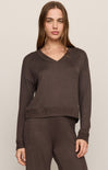 Woman wearing a brown sweater and pants on a beige background