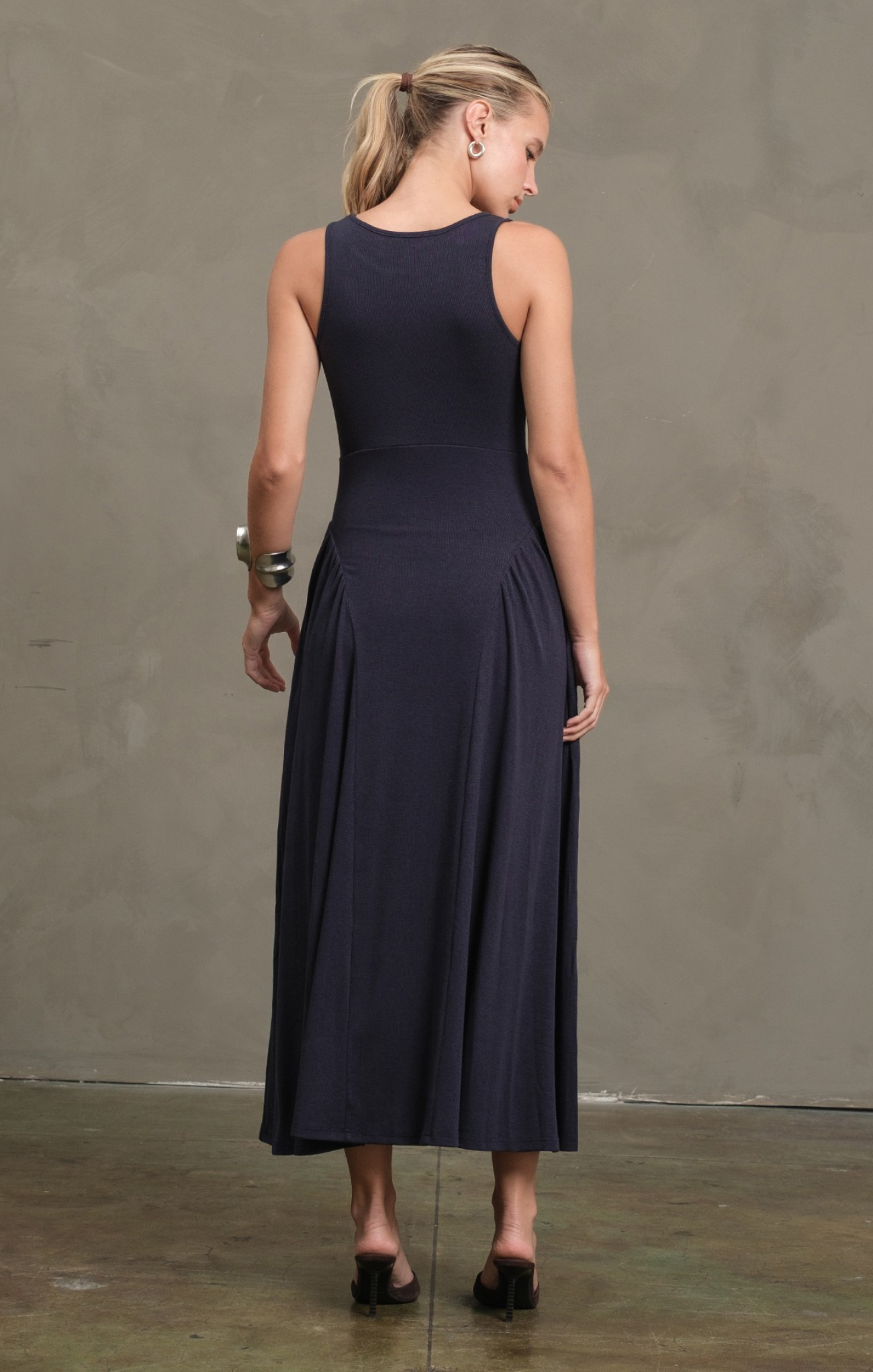 Woman wearing a navy blue dress against a plain background