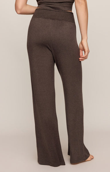 Brown wide-leg pants worn by a person on a beige background