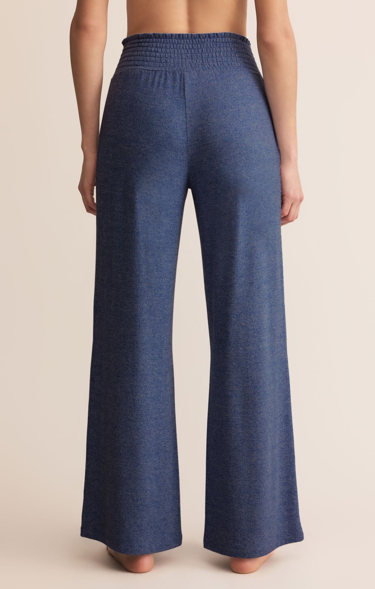 Blue wide-leg pants worn by a person on a beige background