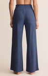 Blue wide-leg pants worn by a person on a beige background