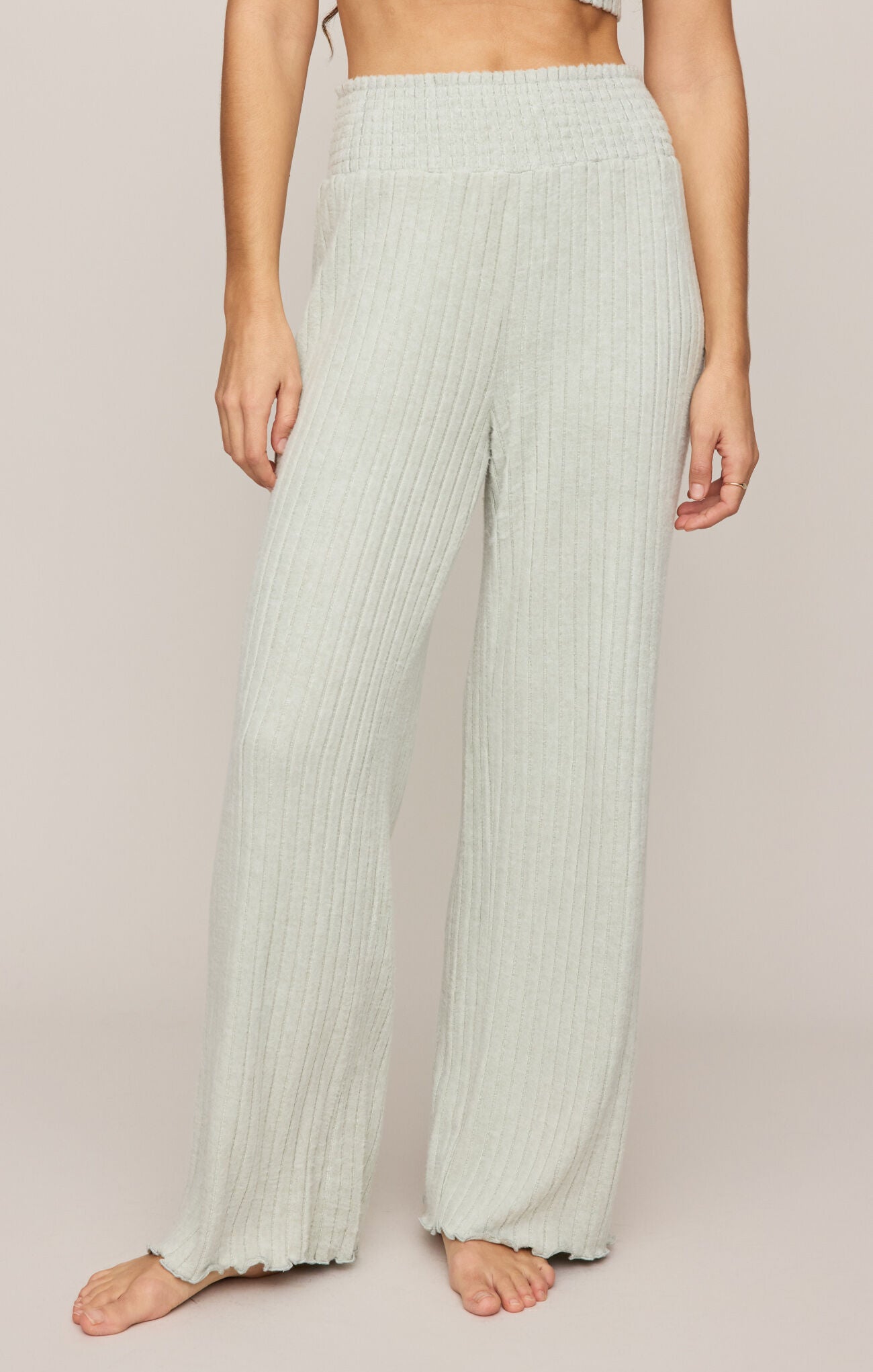 Light green ribbed pants worn by a person on a plain background