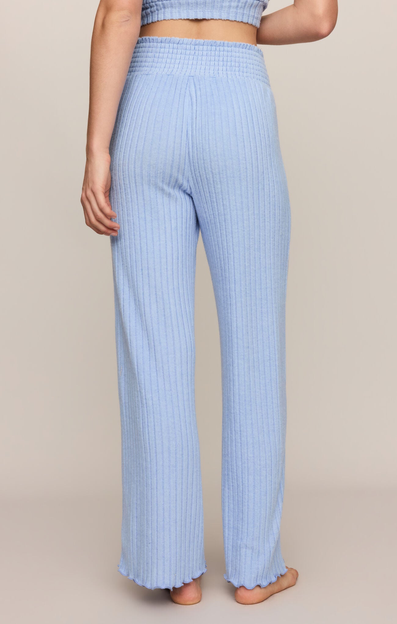 Light blue ribbed pants worn by a person on a beige background