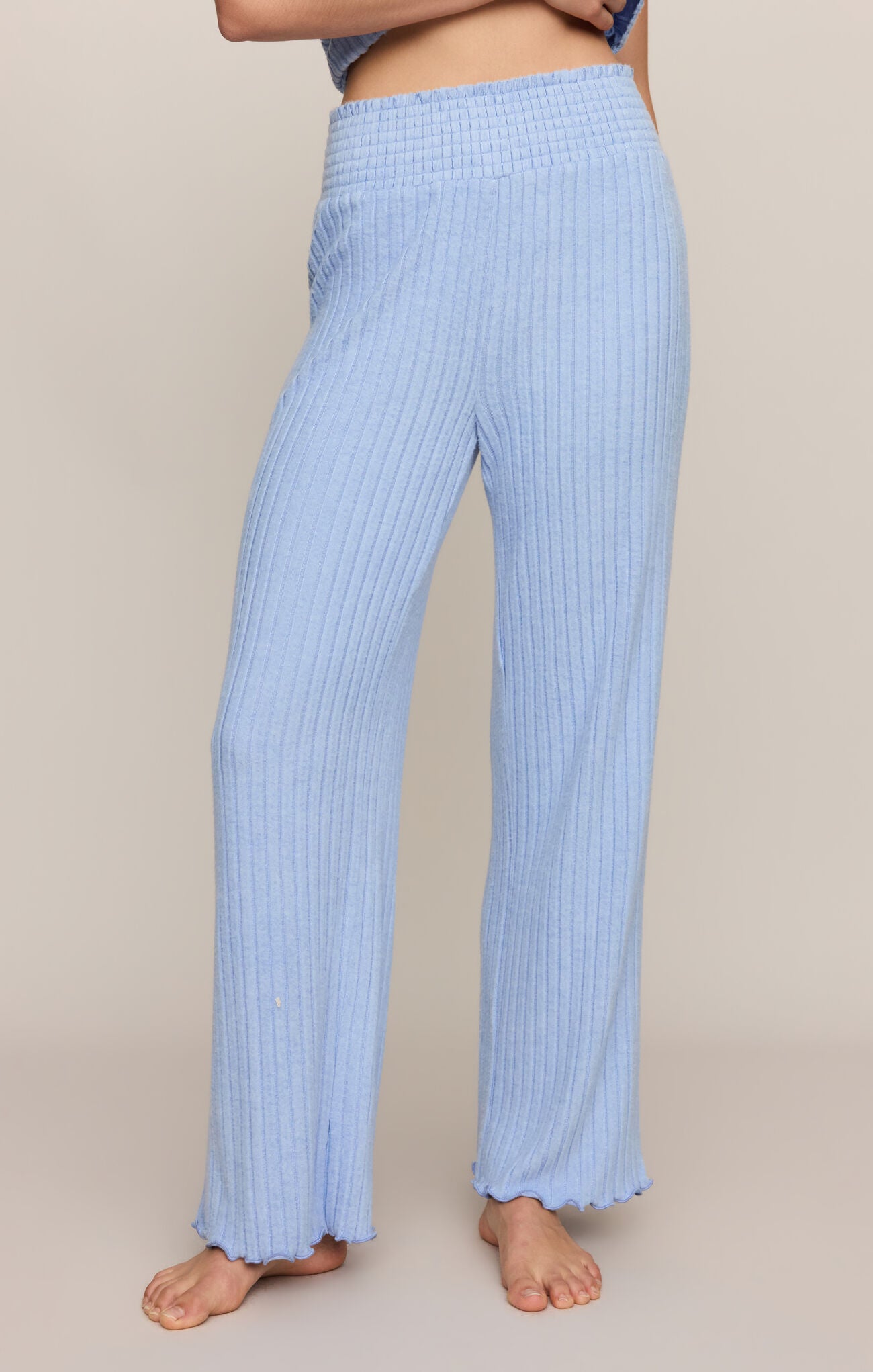 Light blue ribbed pants worn by a person on a beige background