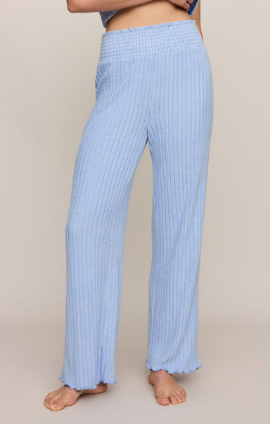 Light blue ribbed pants worn by a person on a beige background