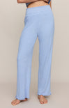 Light blue ribbed pants worn by a person on a beige background