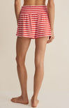 Person wearing red and white striped shorts on a beige background