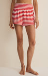 Red and white striped shorts worn by a person on a beige background