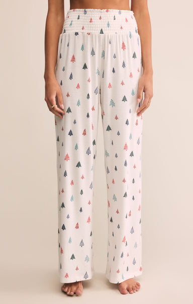Patterned pajama pants worn by a person on a beige background