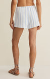 Person wearing light blue and white striped shorts on a beige background