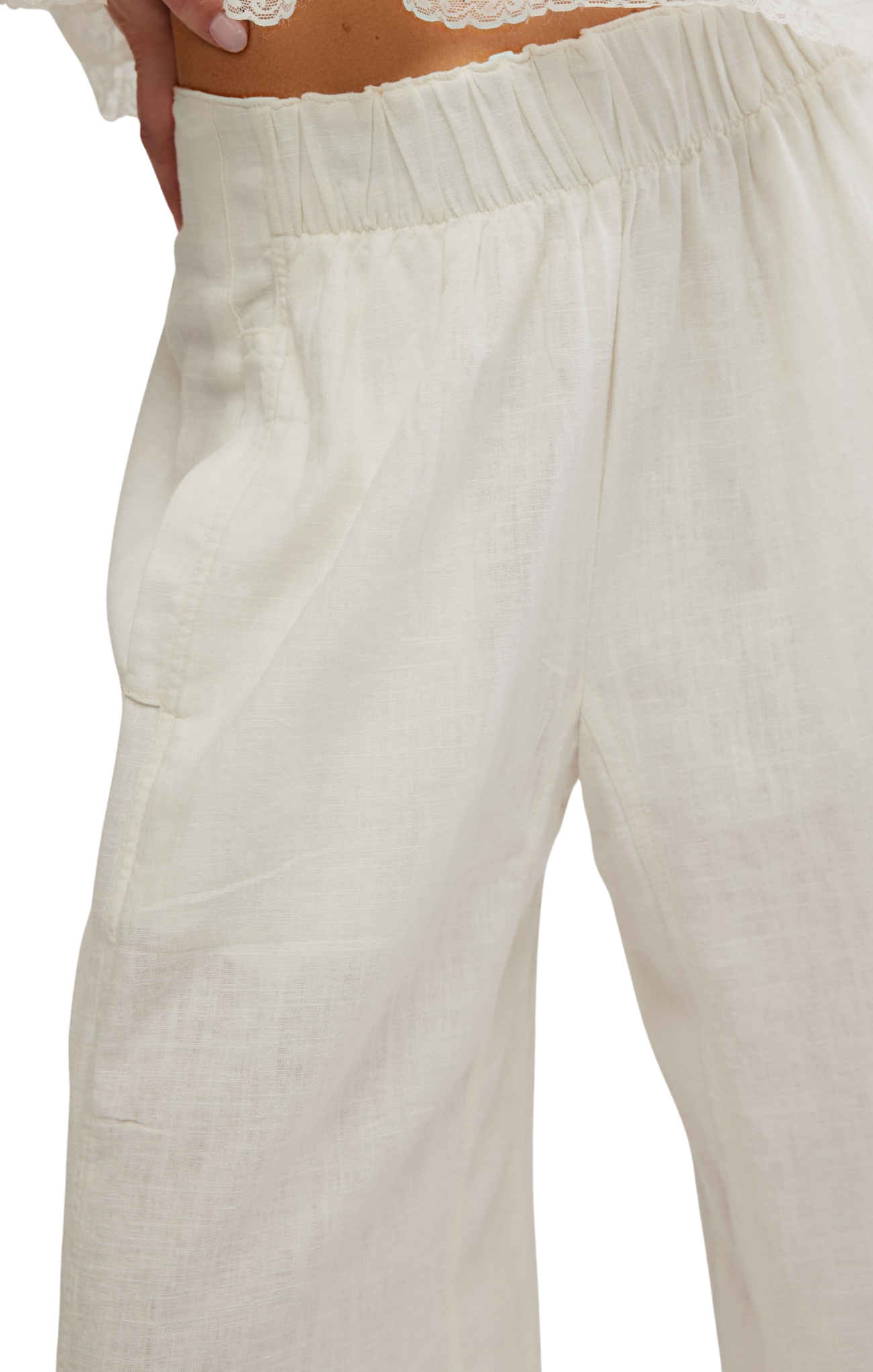 Close-up of white linen pants on a plain background