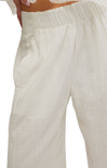 Close-up of white linen pants on a plain background