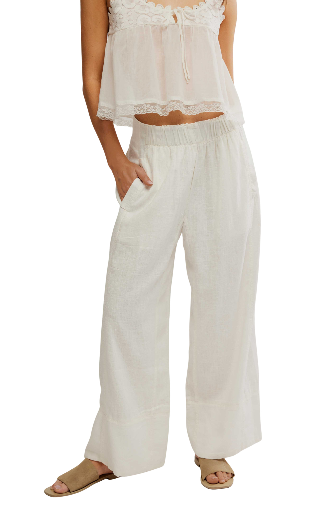 Woman wearing a white outfit with wide-leg pants on a white background