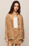 Woman wearing a brown suede jacket and skirt set on a beige background