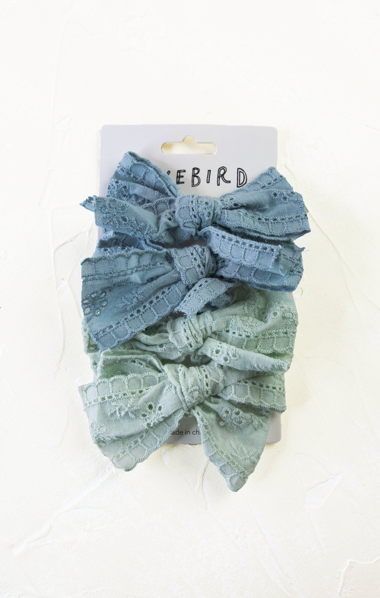 Two denim-colored lace headbands on a white background with 'Bluebird' branding.
